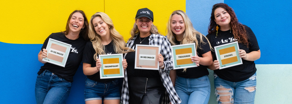 Group of diverse women smiling and holding signs promoting As Is Sis empowerment community