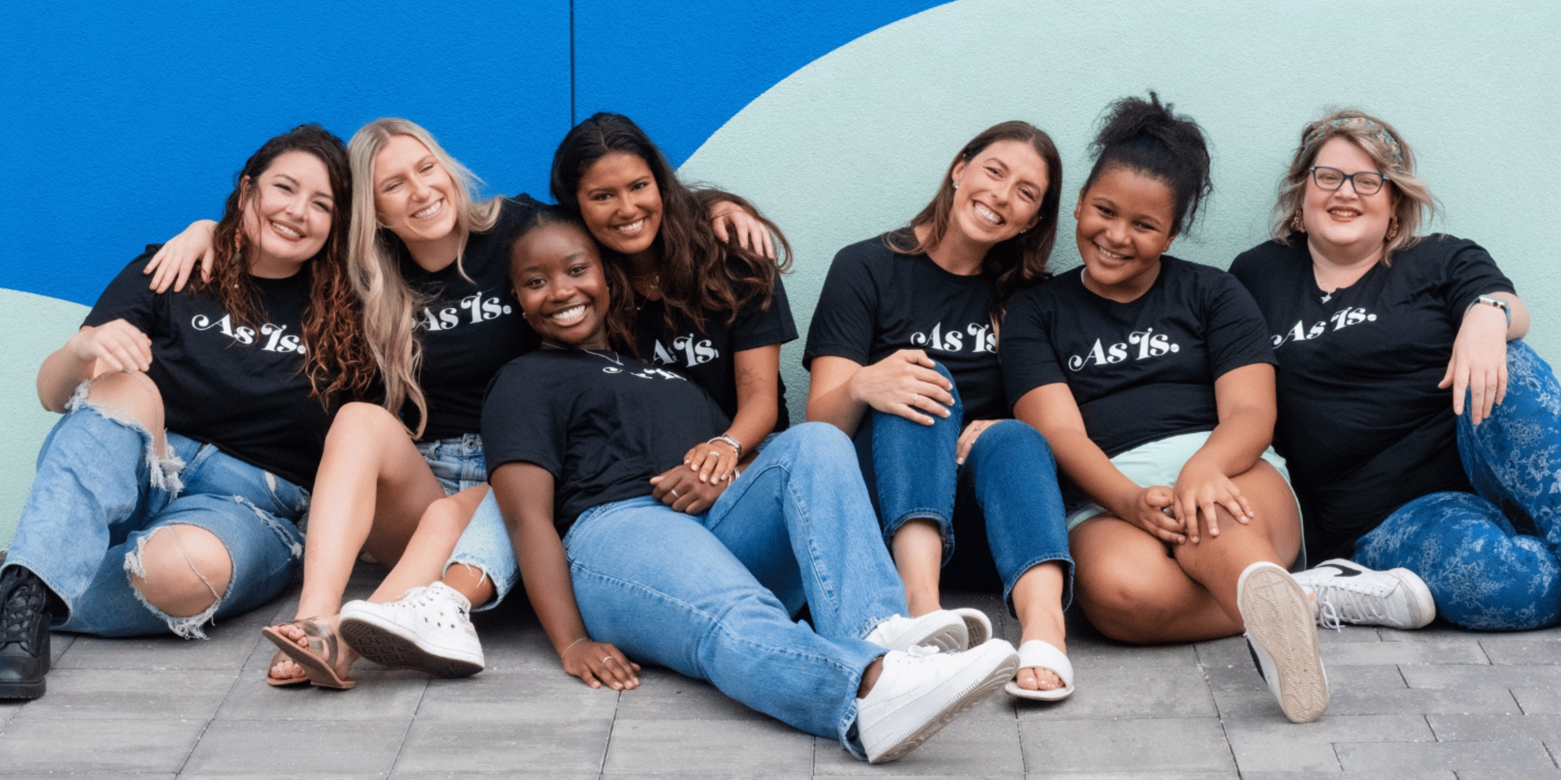 Group of women sitting together in casual outfits, inclusive sisterhood vibe