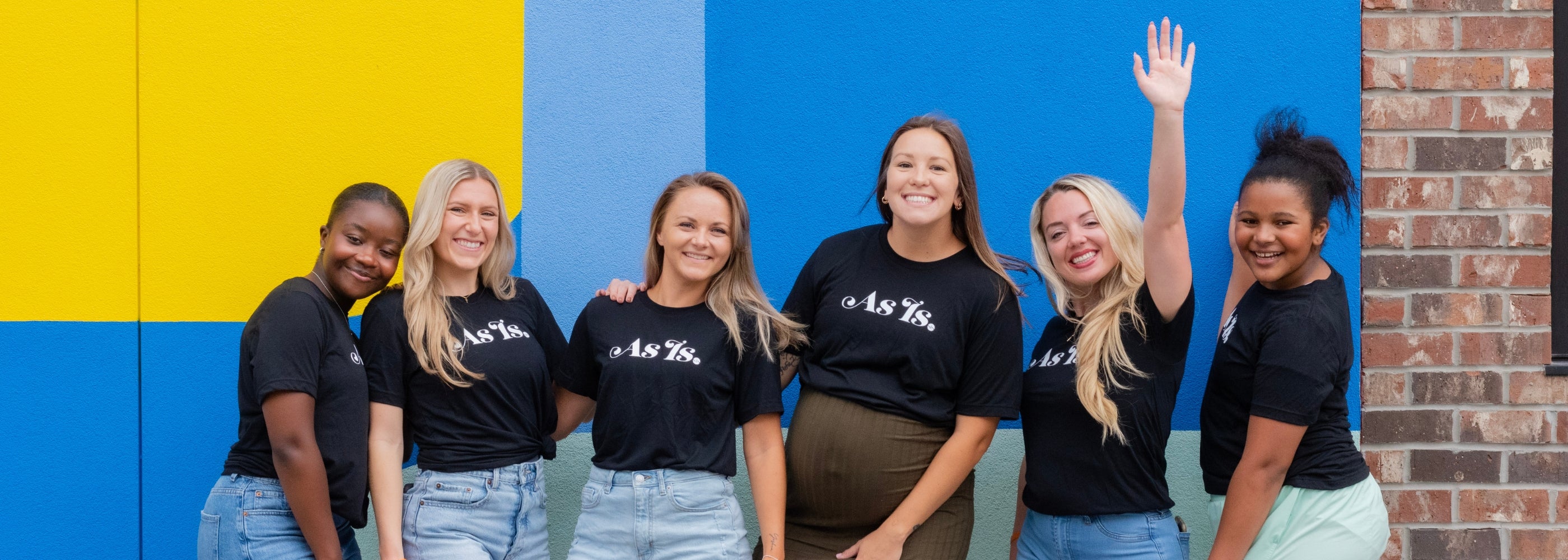 Group of women in branded shirts posing together, empowerment brand community
