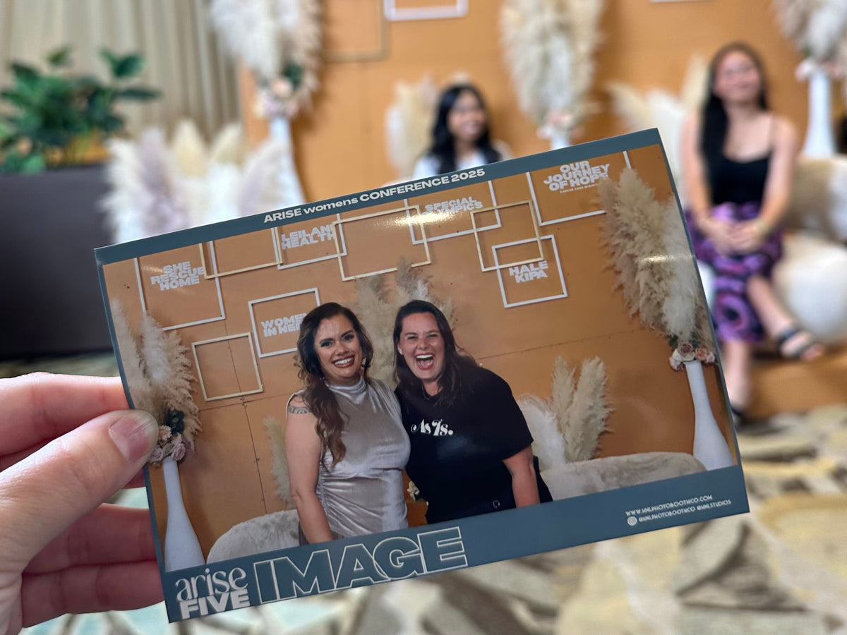 Women posing with custom event photo frame, interactive group activity at empowerment workshop